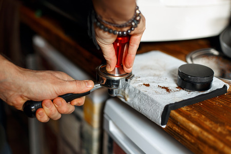 professional barista preparing coffee at his coffee shop working with coffee machine equipment...