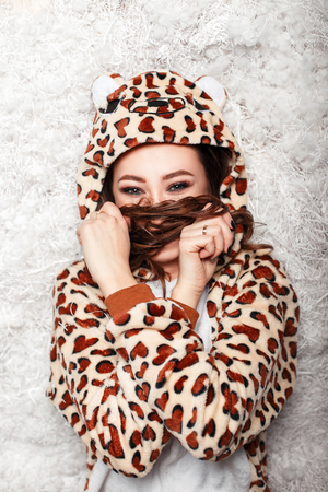 happy young woman in funny pajamas covers face with her hairの写真素材