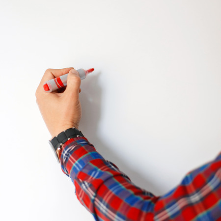 Male hand with a red marker draws on a white board
