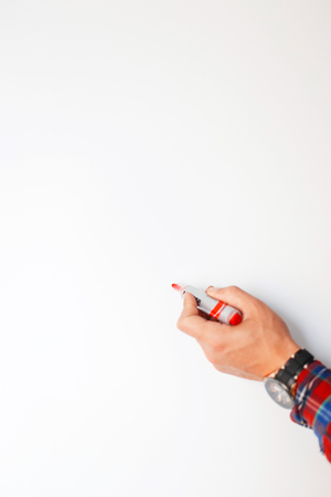 Male hand with a red marker writes on the blackboardの写真素材