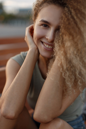Happy beautiful portrait of a curly young girlの写真素材