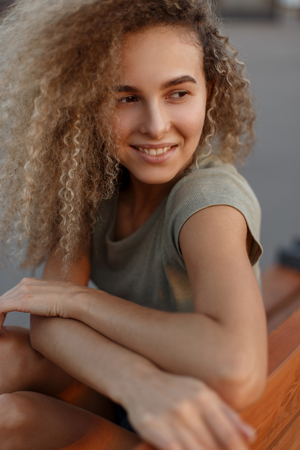 Cheerful portrait of a beautiful cute happy woman with curly hairの写真素材