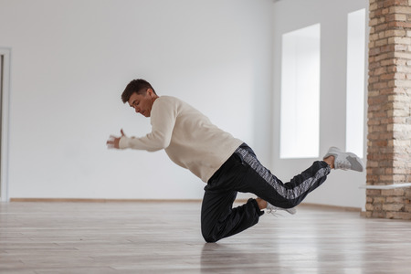 Young modern stylish dancer man dancing on white studioの写真素材