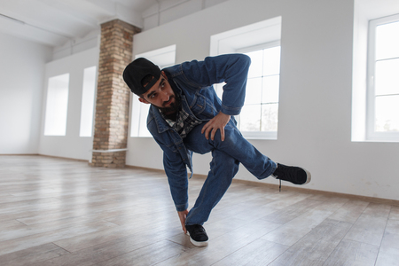 Stylish young man dancer with jeans in jeans clothes dancing in dance studioの写真素材