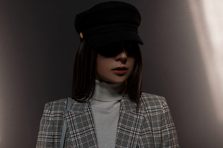 Fashionable portrait of a beautiful young woman in vintage clothes on a dark backgroundの写真素材