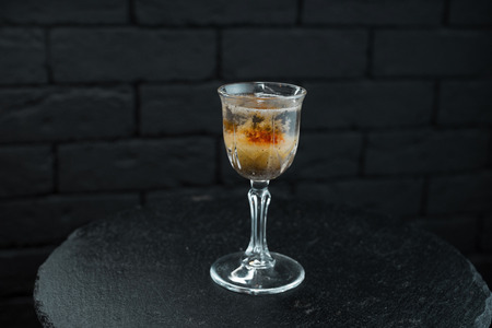 An amazing alcoholic drink in a crystal vintage glass with vodka and white rum with vermouth with...