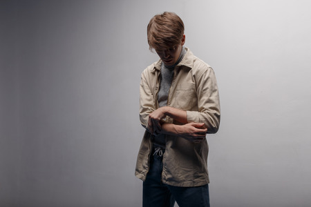 Young man in a fashionable spring jacket in retro style with a fashionable hairstyle in a knitted...