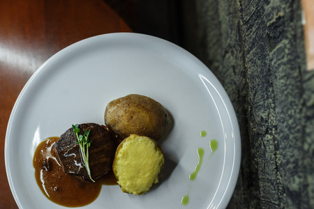 Stuffed potatoes with cheese and with  meat grilled with barbecue sauce on the bar table. Great lunch for gourmets.の写真素材