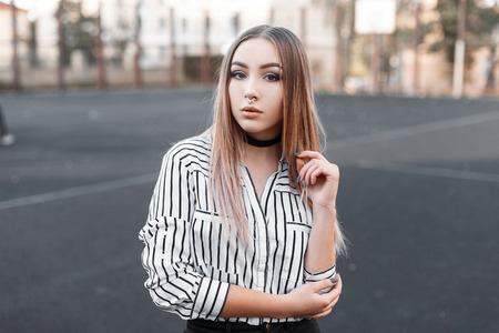 Glamorous young woman in a vintage velvet necklace in a fashionable black and white blouse in a line...