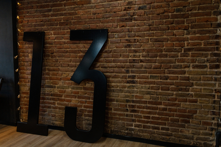 In the room near the vintage brick wall there are big black numerals 13. Original interior of the studio. Retro style.の写真素材