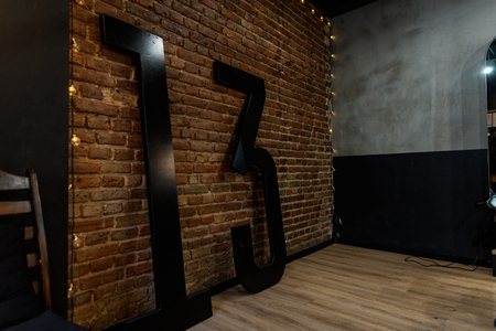 Brick vintage wall with a black number 13. Original interior of a male barbershop. Retro style.の写真素材