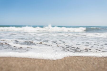 Beautiful blue sky over a restless sea with waves with white foam. Living sea with clear sky on the...