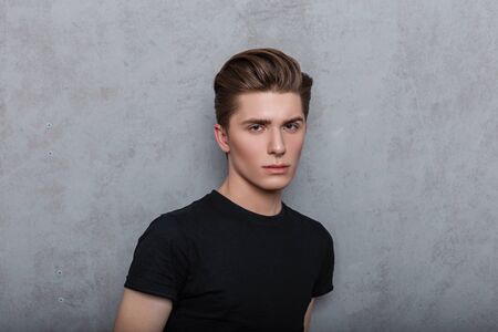 Studio portrait of a fashion young man with clean skin with a pierced nose with a trendy hairstyle...