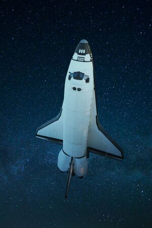 Space shuttle flies in space against the blue background of stars. Space shuttle taking off on a missionの写真素材