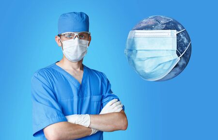 Professional doctor man in a medical mask with the planet Earth in a mask with a virus on a blue...