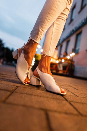 Woman in fashionable summer shoes on the night streetの写真素材