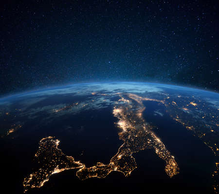 Beautiful blue planet earth with night city lights. Central Europe and Italy at night view from space. Modern cities and electricityの写真素材