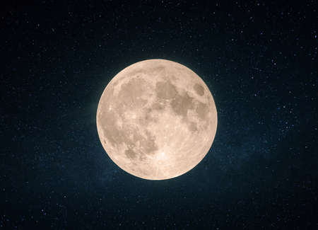 Beautiful yellow full moon with craters in the starry sky.の写真素材