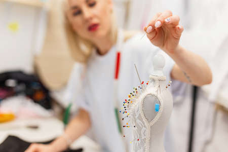Fashion designer clothes takes a needle in the studio. Set of sewing needles in a mannequin....