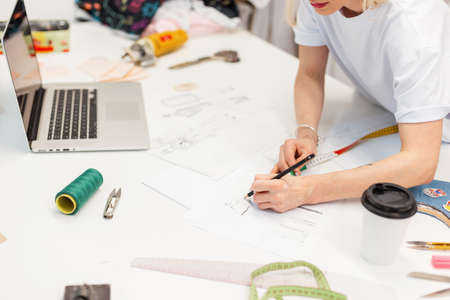 Fashion designer draws a sketch in the studio. creative workplace for clothing production.