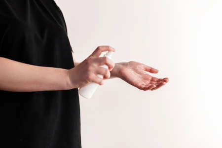 Hand of lady that applying alcohol spray or anti bacteria spray to prevent spread of germs, bacteria and virus on a white background. Personal hygiene concept.の写真素材
