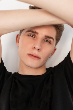 Studio portrait pretty good-looking young man with trendy hairstyle with beautiful gray eyes with...