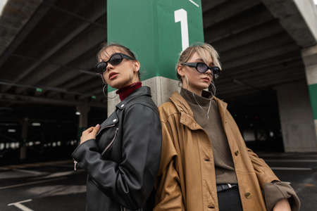 Fashionable beautiful stylish women sisters in modern youth style with cool sunglasses in leather...