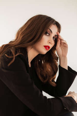 Fashion portrait of beautiful woman with makeup and curly hairstyle in fashion black elegant clothes...