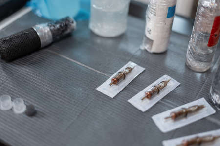 set of tools for a tattoo artist with a machine, a needle and paints at the workspace, close-upの写真素材