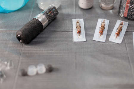 Desktop with tattoo tools. Master's tattoo workspace with typewriter, needles and paintの写真素材