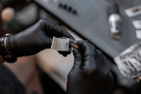 male tattoo artist prepares for work and takes out a needle.の写真素材