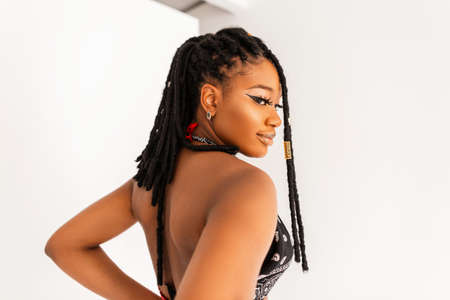 Portrait of sexy beautiful young black woman with cool dreadlocks in stylish bandana top with open...