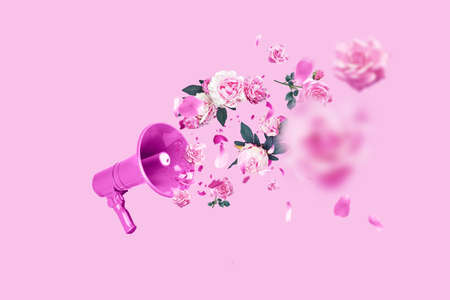 Pink creative megaphone and flat pink flowers roses and peonies on a pastel pink background. Concept creative idea of spring and women's day. Flora, flowers and beautyの写真素材