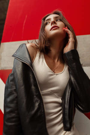 Beautiful fashionable sexy model woman in fashionable urban clothes with a leather jacket and dress...