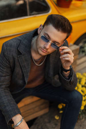 Stylish handsome young businessman guy hipster with hairstyle in fashionable casual clothes with...