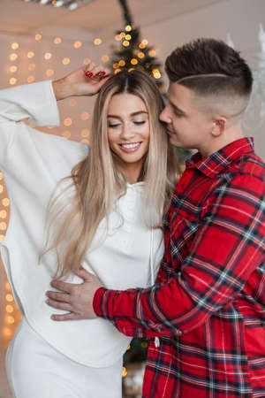 Beautiful happy young couple in love in fashionable clothes at home. Beauty smiling girl with her husband, insurance conceptの写真素材