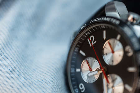 Expensive luxury watch with chronograph and clock on jeans texture, close-up. business and success conceptの写真素材