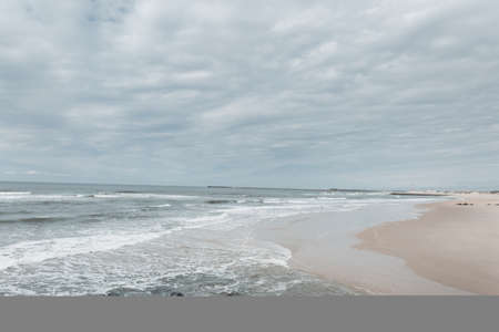 Exuberant ocean with waves and a cloudy gray sky. Traveling in Portugal. sea viewの写真素材