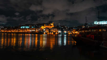 Beautiful European old night town of Porto near the river. Vintage city of Porto, Portugal with lightsの写真素材
