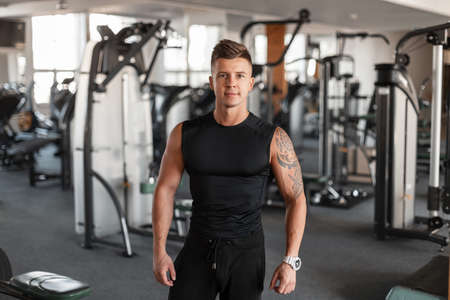 Portrait of a handsome fashionable athletic man model with hairstyle and a perfect muscular body in...