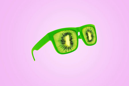 Creative green kiwi glasses hovering over a pastel pink background. Creative idea for vitamins and health. Juicy exotic summer concept. Vitamins raw. color combinationの写真素材