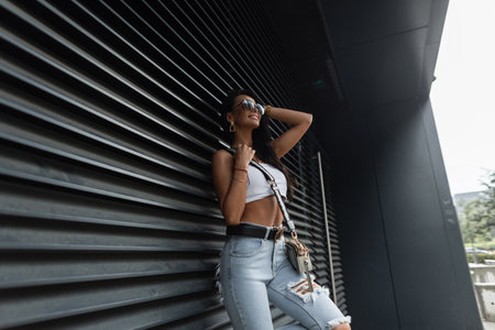 Happy fashion beautiful woman with smile with stylish sunglasses in trendy casual urban clothes with...