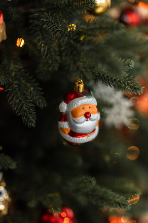 Santa Claus toy hanging on the Christmas tree with lights. Merry Christmas and Happy New Yearの写真素材