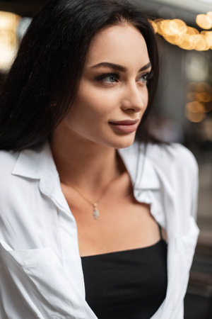 Street portrait of beautiful fashionable business woman model with white shirt and black top in the...