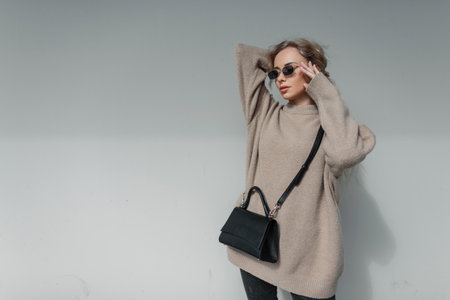 Stylish beautiful fashion woman with blond curly hairstyle with trendy vintage sunglasses in a...