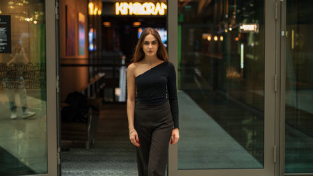 Stylish beautiful woman model in fashionable black elegant clothes with trousers and a black...