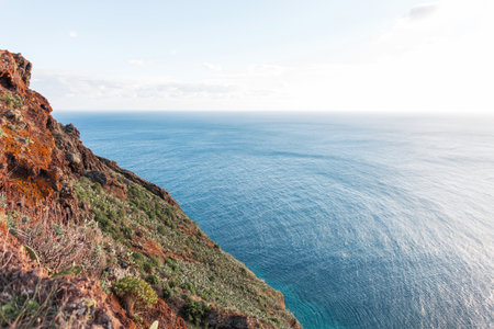 Beautiful blue ocean and red mountain in Madeira islandの写真素材