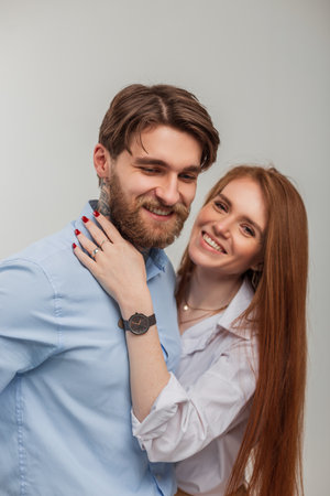 Happy beautiful young couple in fashionable clothes. Beautiful happy redhead woman with smile and handsome hipster man with tattoo and beardの写真素材