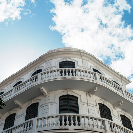 White vintage building apartment with windows and railings on a background of a blue sky with clouds in the city of Funchal, Madeira islandのeditorial素材