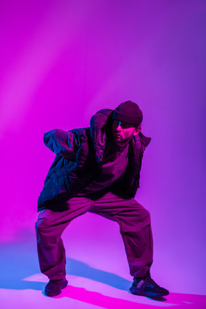 Professional dancer guy in fashionable clothes dancing in a colorful creative studioの写真素材
